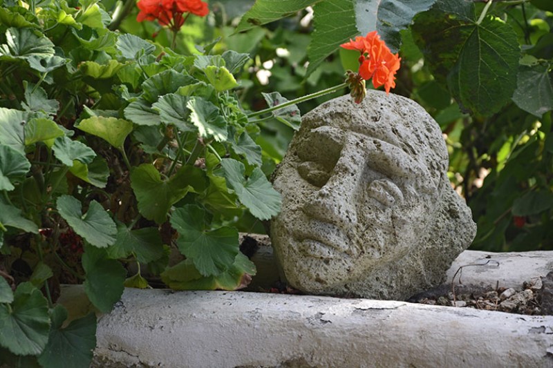 Scultura di testa femminile nel giardino / Photo©Silvana Matozza